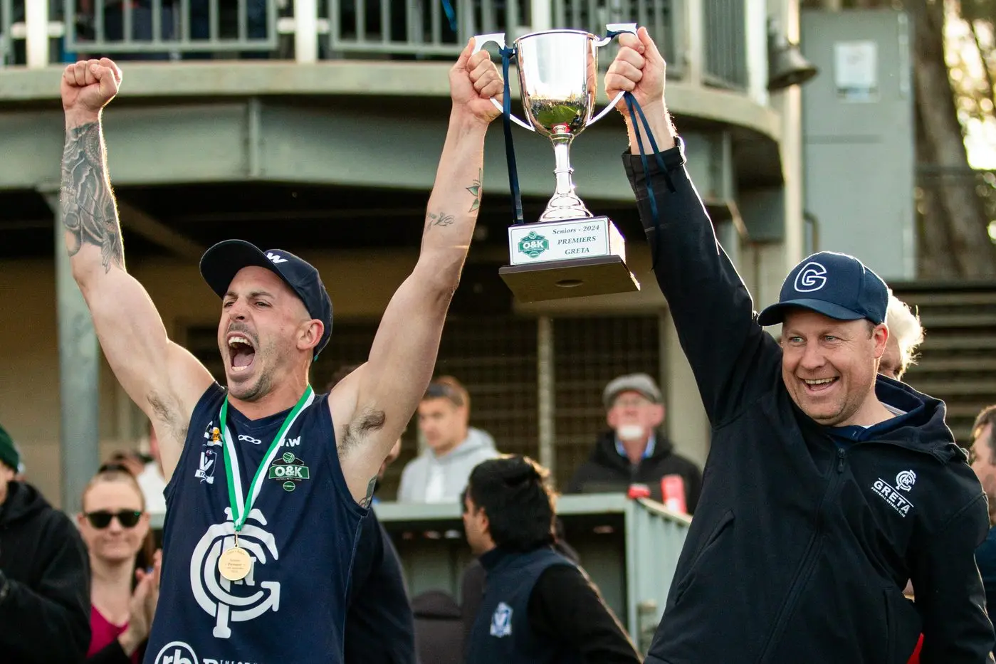 RAISE THE CUP: Greta captain Josh Bell and coach Chris Dube hoist the senior premiership cup after Greta\\'s 68-point win over Bright. PHOTOS: Marc Bongers