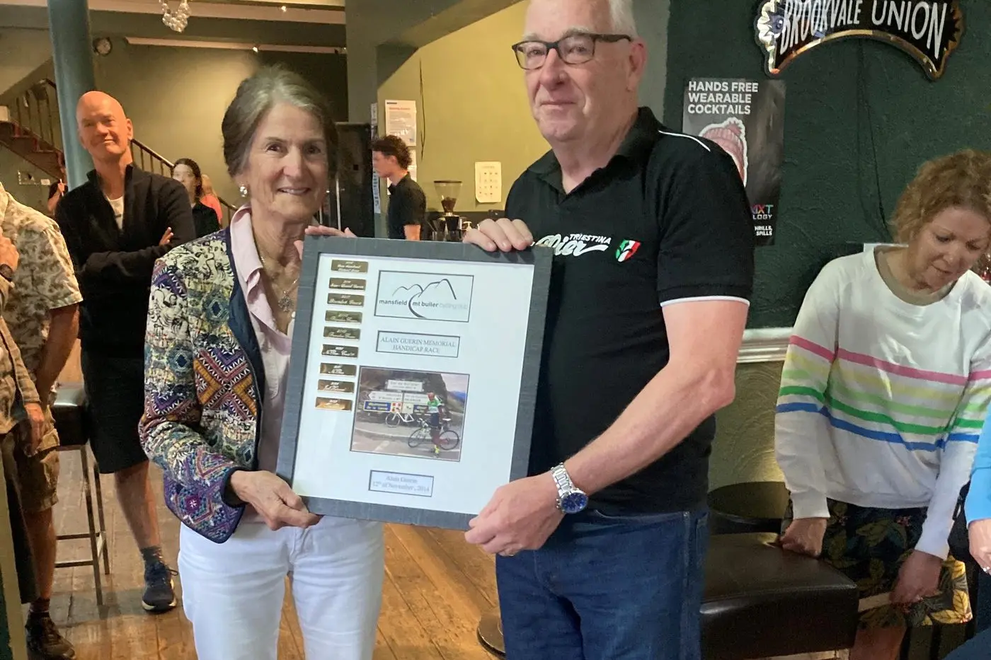 REMEMBERING ALAIN: (from left) Coral Guerin presents the Alain Guerin Memorial Handicap race trophy to Craig Wilson. PHOTO: Bruce Halket