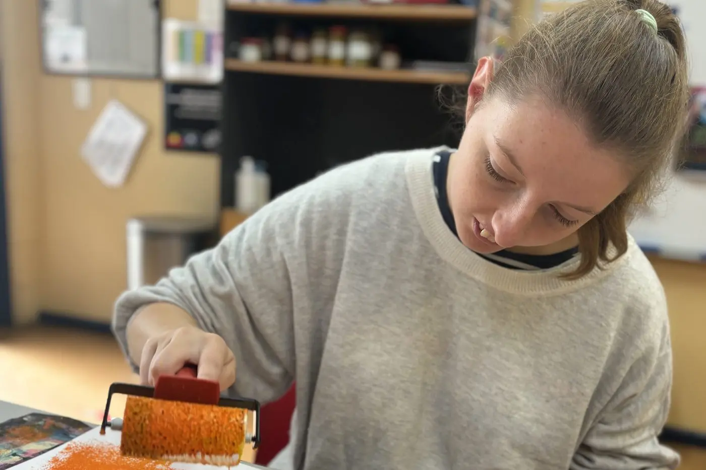 CREATIVE MINDS: Lily creating a colourful artwork using a paint roller. PHOTOS: Yooralla Mansfield Community Hub