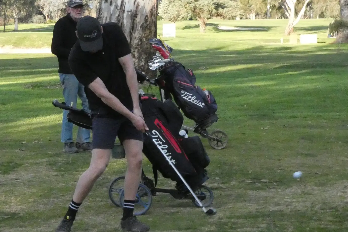 LOOKING GOOD: James Octigan shows a perfect approach swing on the seventeenth hole in front of Brad Grant.. PHOTO: Phil Conway