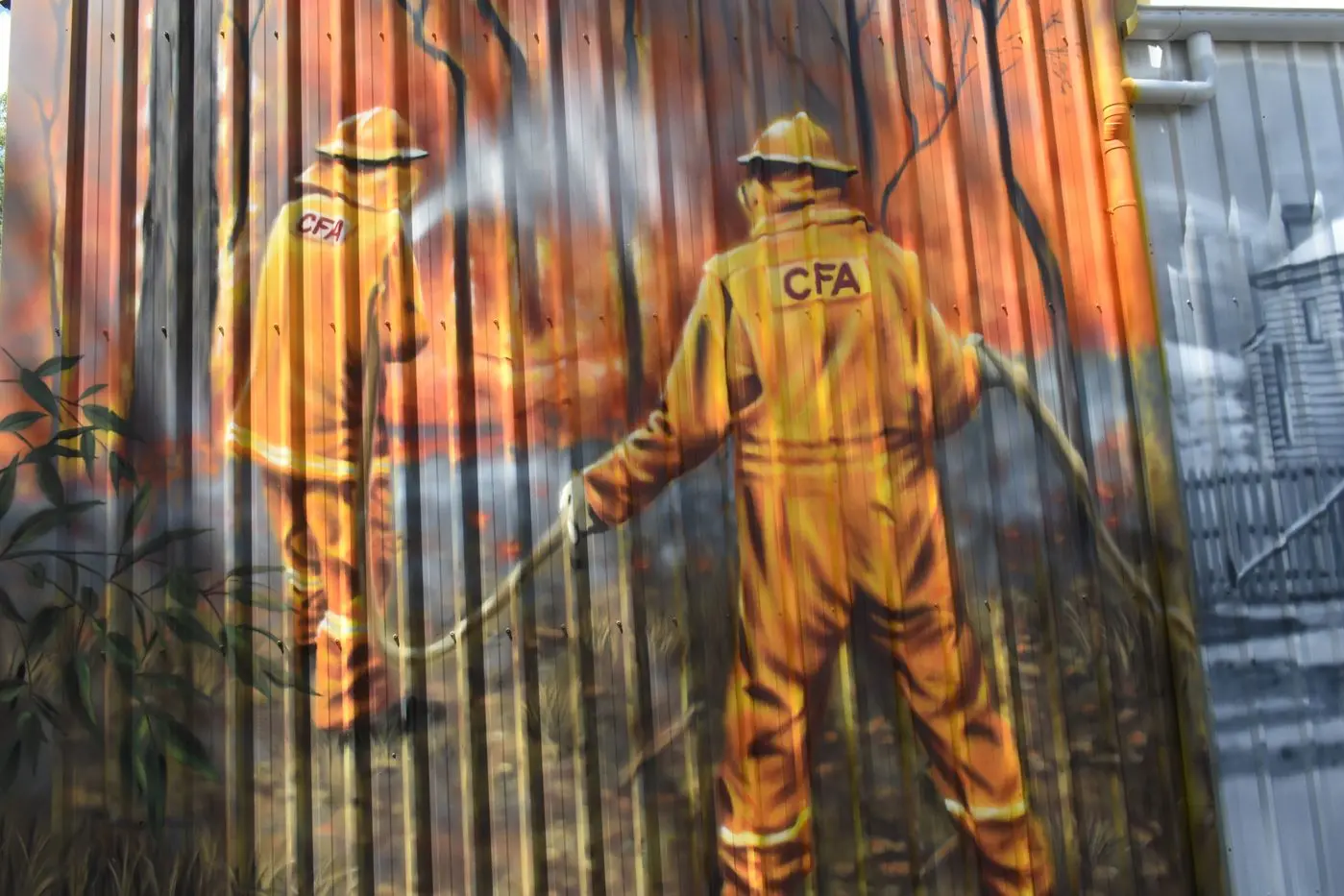 VOLUNTEERS: CFA volunteers fighting a fire are depicted in the northern end of the shed wall.