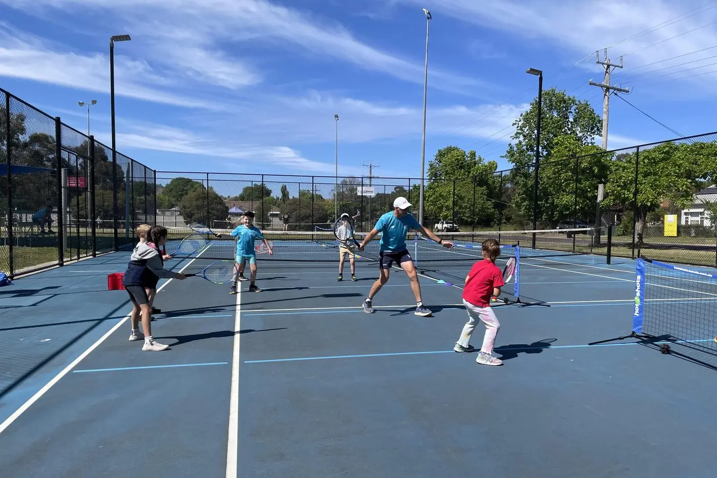 NEW SKILLS: Liam Delany demos the forehand and Zoe Speirs joins in the fun with Eden, Edward, Flynn, Jaydah and Amelia. PHOTO: Rhonda Carpenter