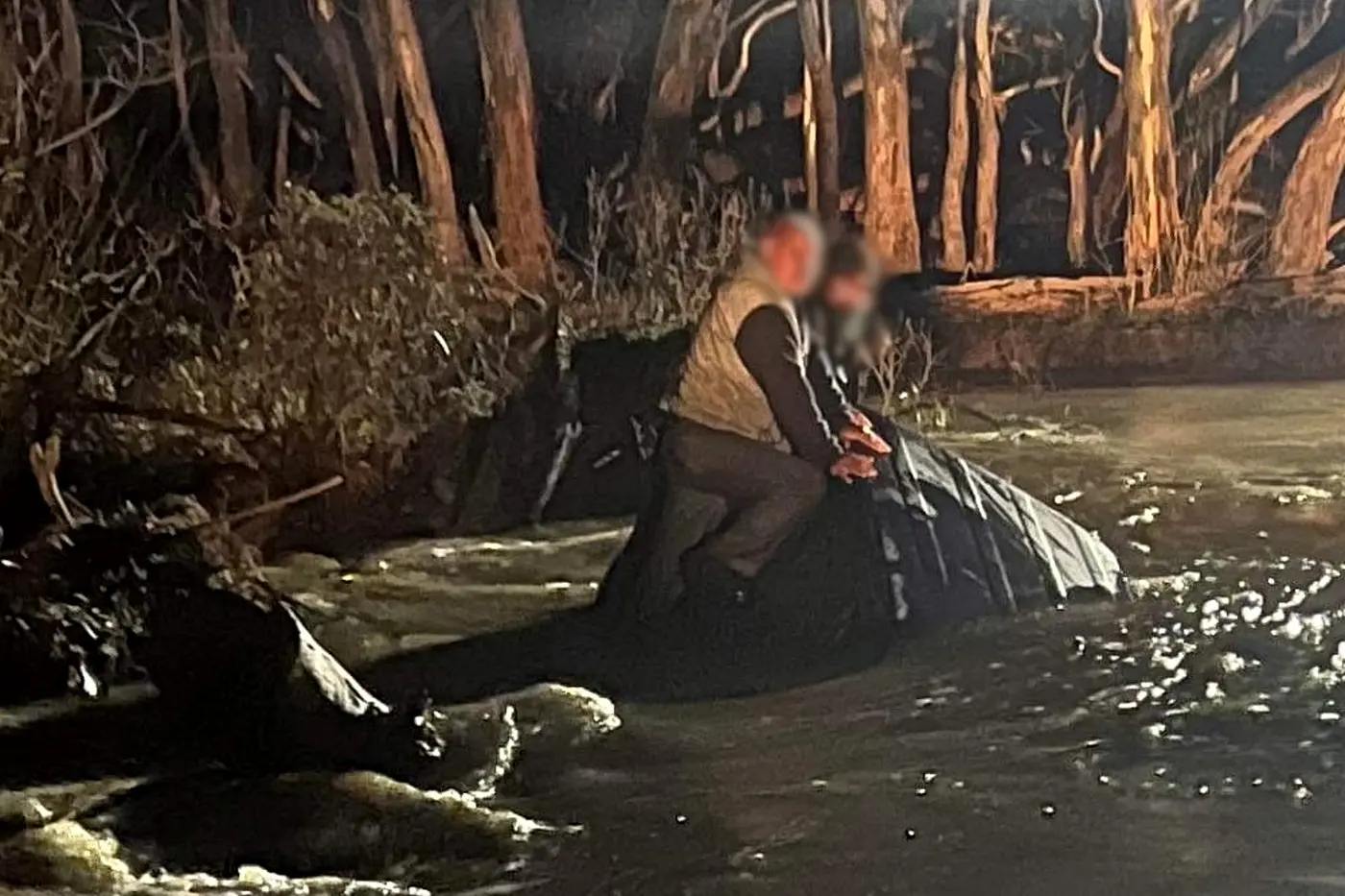TRAPPED: Two men, one in his seventies and his son in his forties, sat trapped atop their car as fast\\u2013flowing, approximately 1.6 metre deep floodwater surrounded them. The men reportedly drove into floodwater after mistaking it for a large puddle. PHOTO: Victoria Police